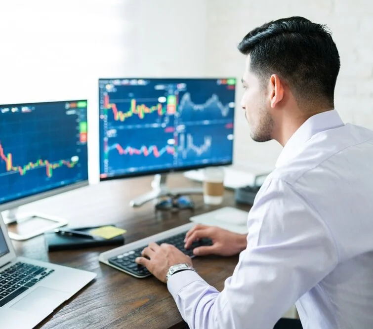 Un homme devant son ordinateur étudie des graphiques